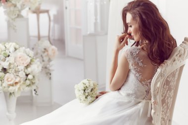 The beautiful woman posing in a wedding dress