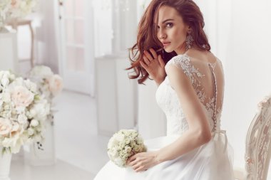 The beautiful woman posing in a wedding dress