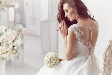 The beautiful woman posing in a wedding dress