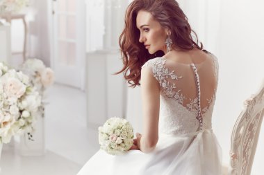 The beautiful woman posing in a wedding dress