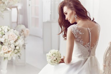 The beautiful woman posing in a wedding dress