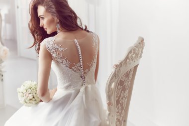 The beautiful woman posing in a wedding dress