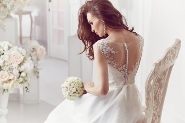 The beautiful woman posing in a wedding dress