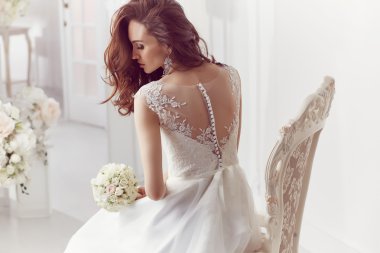 The beautiful woman posing in a wedding dress