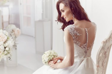 The beautiful woman posing in a wedding dress