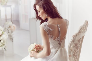 The beautiful woman posing in a wedding dress