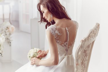 The beautiful woman posing in a wedding dress