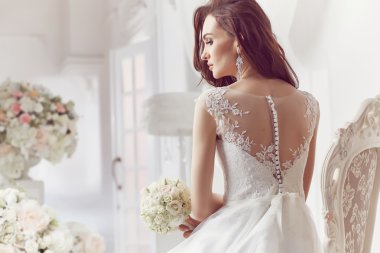 The beautiful woman posing in a wedding dress