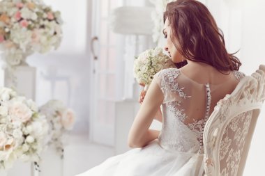 The beautiful woman posing in a wedding dress