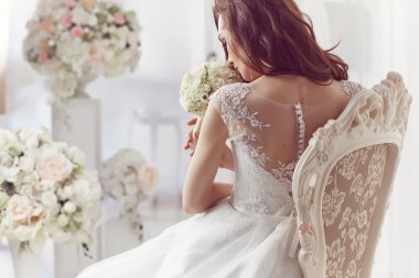 The beautiful woman posing in a wedding dress