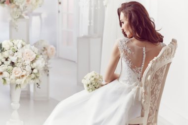 The beautiful woman posing in a wedding dress