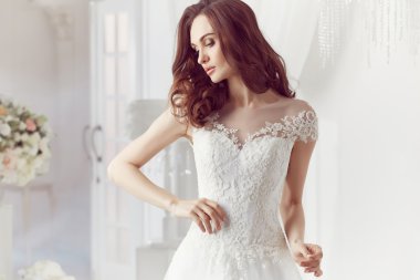 The beautiful woman posing in a wedding dress
