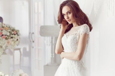 The beautiful woman posing in a wedding dress