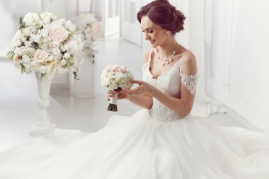 The beautiful woman posing in a wedding dress