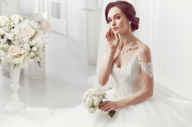 The beautiful woman posing in a wedding dress