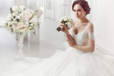 The beautiful woman posing in a wedding dress