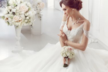The beautiful woman posing in a wedding dress