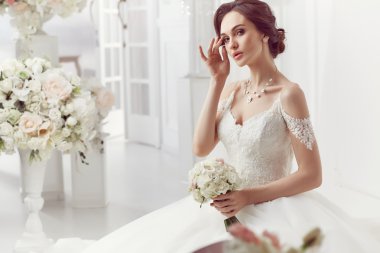 The beautiful woman posing in a wedding dress