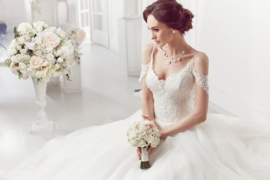The beautiful woman posing in a wedding dress