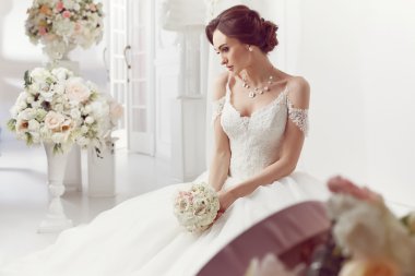The beautiful woman posing in a wedding dress