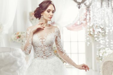 The beautiful woman posing in a wedding dress
