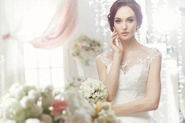 The beautiful woman posing in a wedding dress