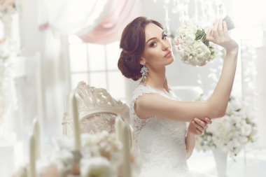 The beautiful woman posing in a wedding dress