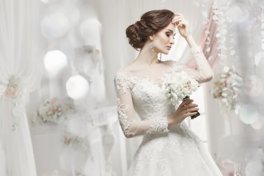 The beautiful woman posing in a wedding dress