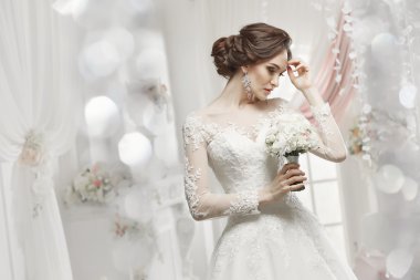 The beautiful woman posing in a wedding dress