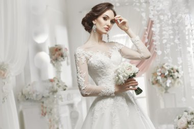 The beautiful woman posing in a wedding dress