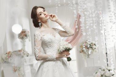 The beautiful woman posing in a wedding dress
