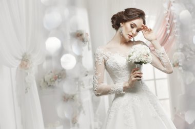 The beautiful woman posing in a wedding dress