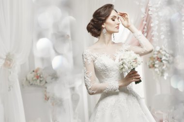 The beautiful woman posing in a wedding dress