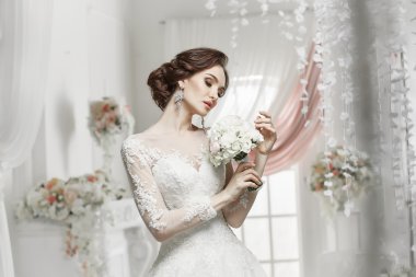 The beautiful woman posing in a wedding dress
