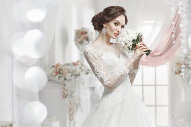 The beautiful woman posing in a wedding dress