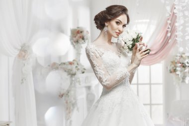 The beautiful woman posing in a wedding dress