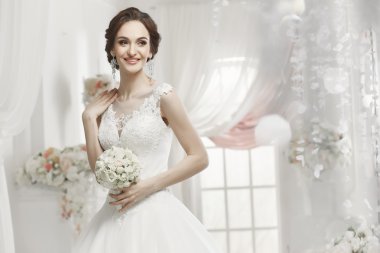 The beautiful woman posing in a wedding dress