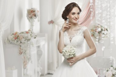 The beautiful woman posing in a wedding dress