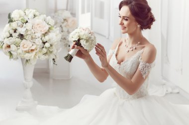 The beautiful woman posing in a wedding dress