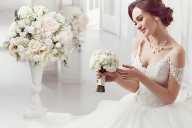 The beautiful woman posing in a wedding dress