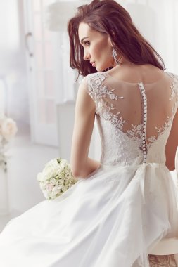 The beautiful woman posing in a wedding dress