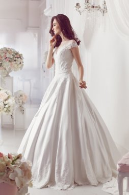 The beautiful woman posing in a wedding dress