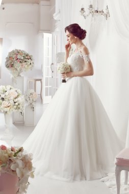 The beautiful woman posing in a wedding dress