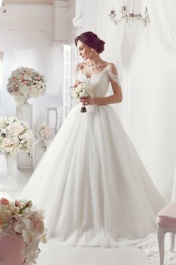 The beautiful woman posing in a wedding dress