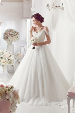 The beautiful woman posing in a wedding dress