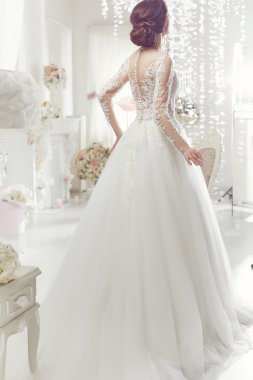The beautiful woman posing in a wedding dress