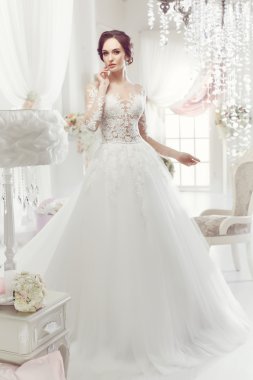 The beautiful woman posing in a wedding dress