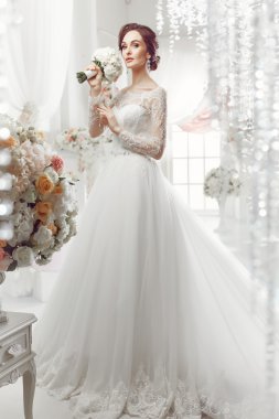 The beautiful woman posing in a wedding dress