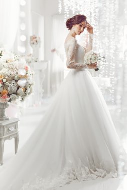 The beautiful woman posing in a wedding dress