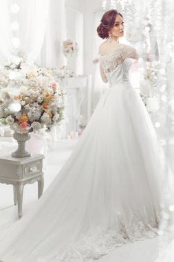 The beautiful woman posing in a wedding dress